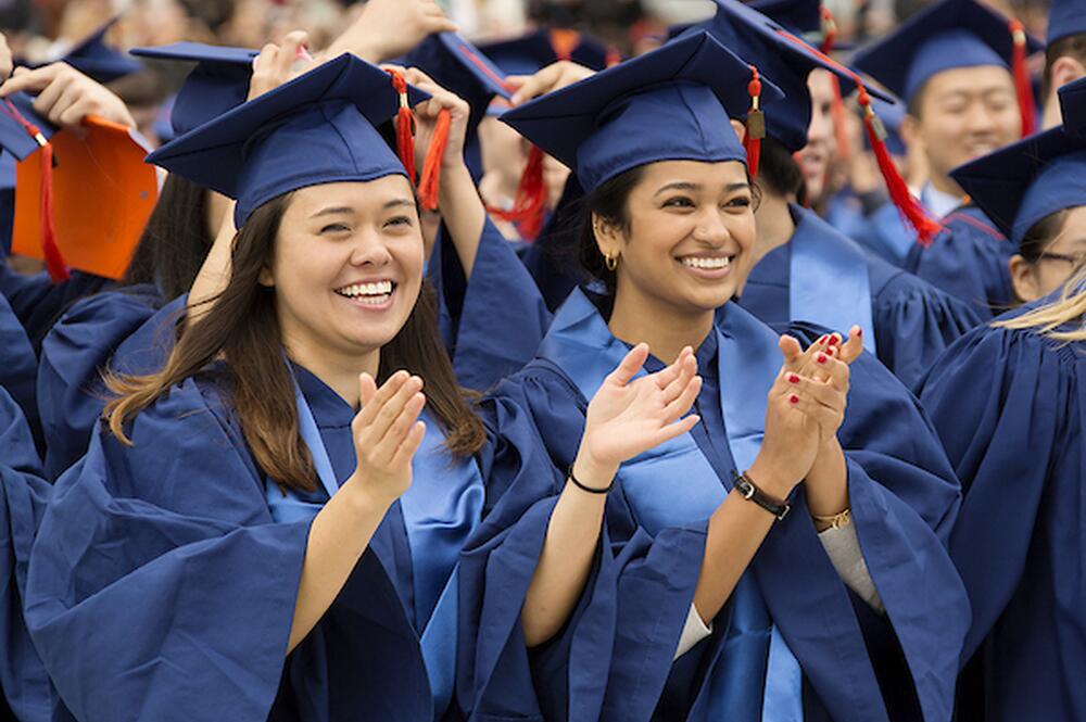 Two students in graduation caps and gowns.